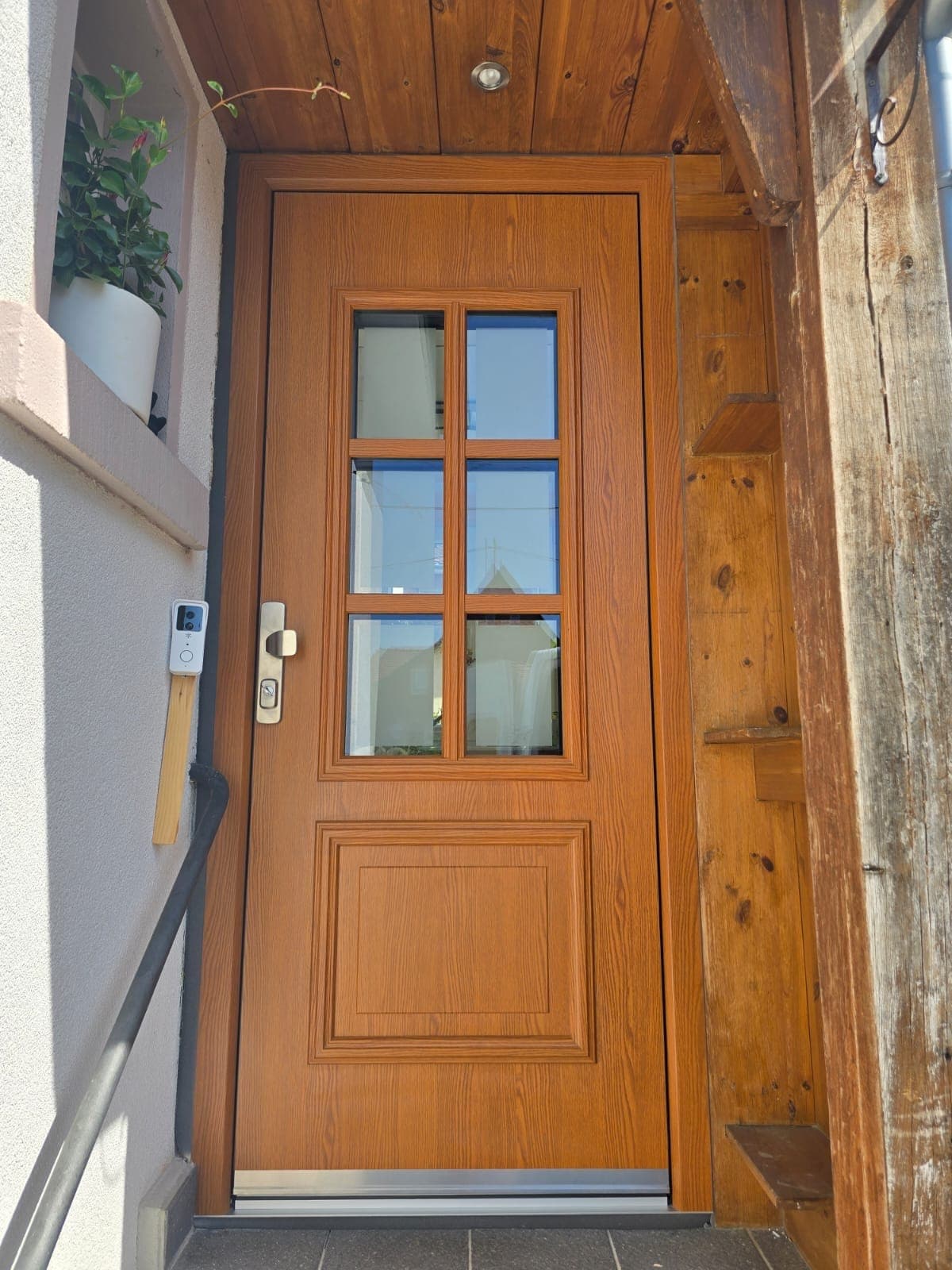 Eingebaute Haustür in Eiche-Holzoptik mit sechsteiligem Sprossenfenster am Fachwerkhaus